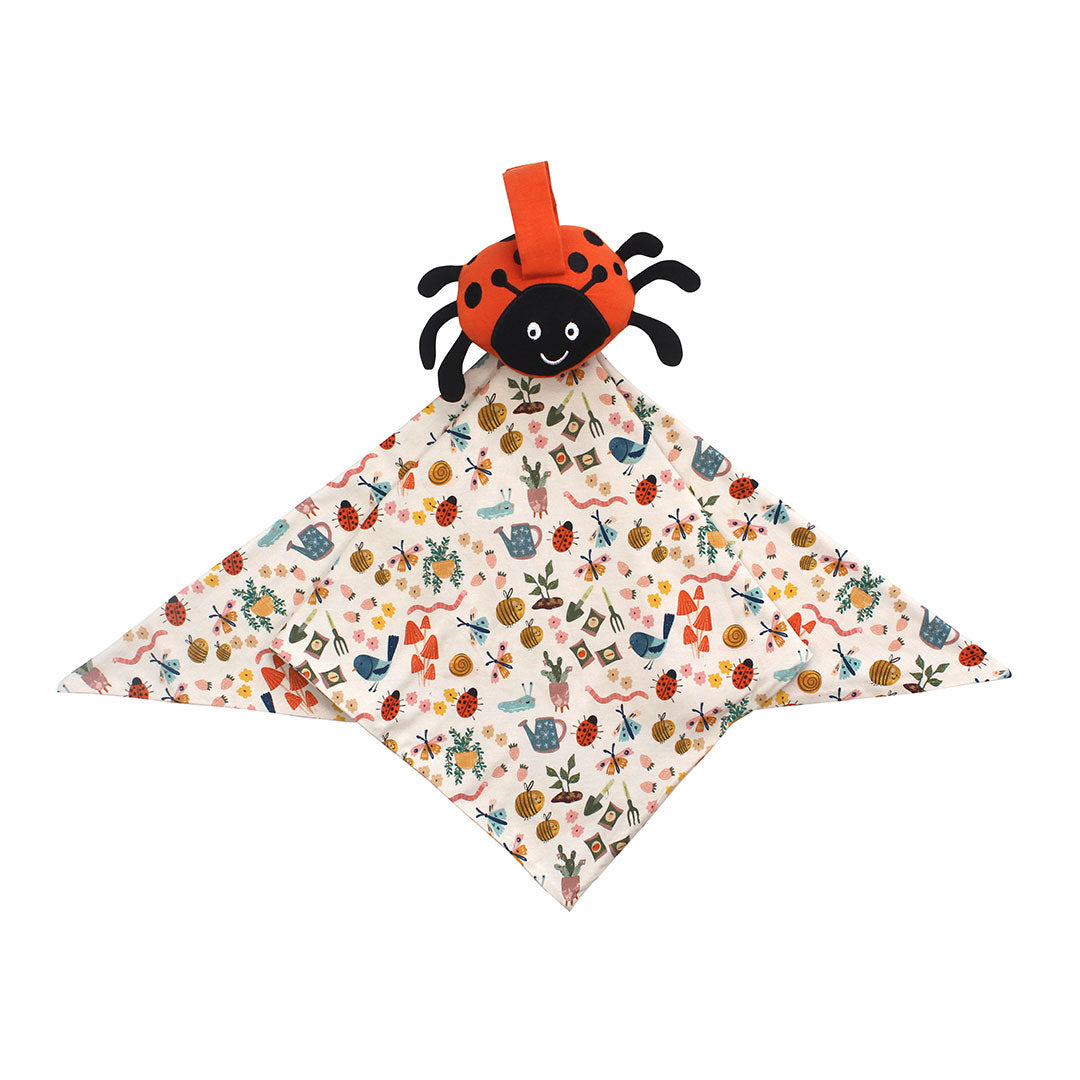 Flat lay ladybug lovey on a white background.