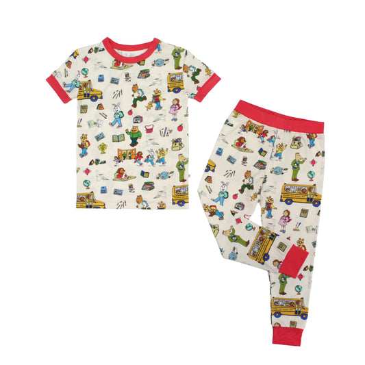Short Sleeve Kids Pajama Pants Set from buttery-soft bamboo, featuring red trims and playful illustrations of Arthur™ PBS Character, books, and school bus, a beige background.
