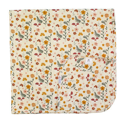 cream bamboo blanket with mushroom print on white background. 