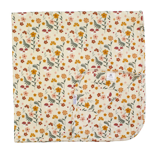 cream bamboo blanket with mushroom print on white background. 