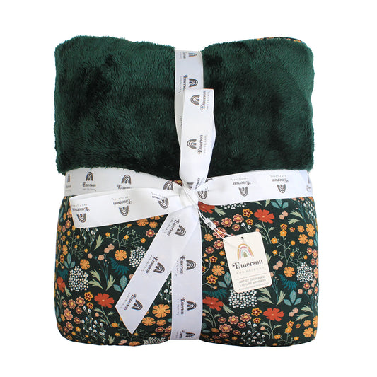 dark green bamboo blanket with green fleece and floral print on white background. 