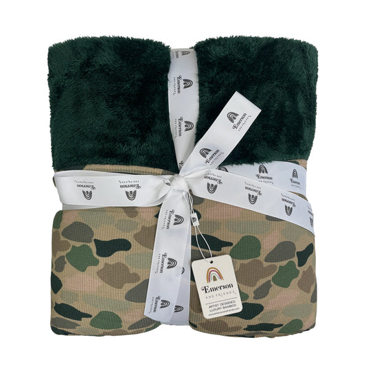 bamboo blanket with camo print and green fleece lining on white background.