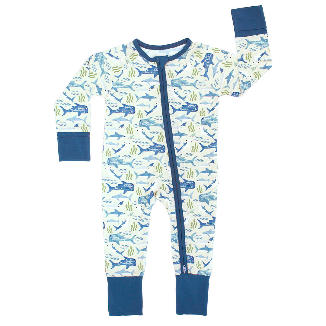 Flay lay of the Shark Friends convertible pajama. The print includes various types of sharks, great whites, hammerheads, whale sharks, and more. It also has schools of fish and beds of seaweed amongst the sharks.