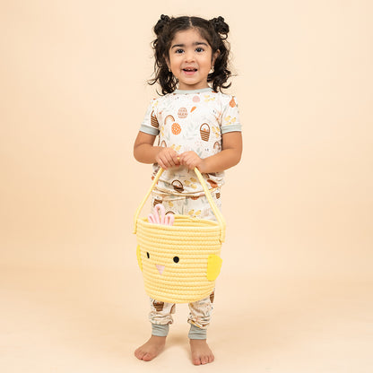 Toddler holding the yellow basket. Side view of yellow chicken basket showcasing the handle, with a cute face on the front.

