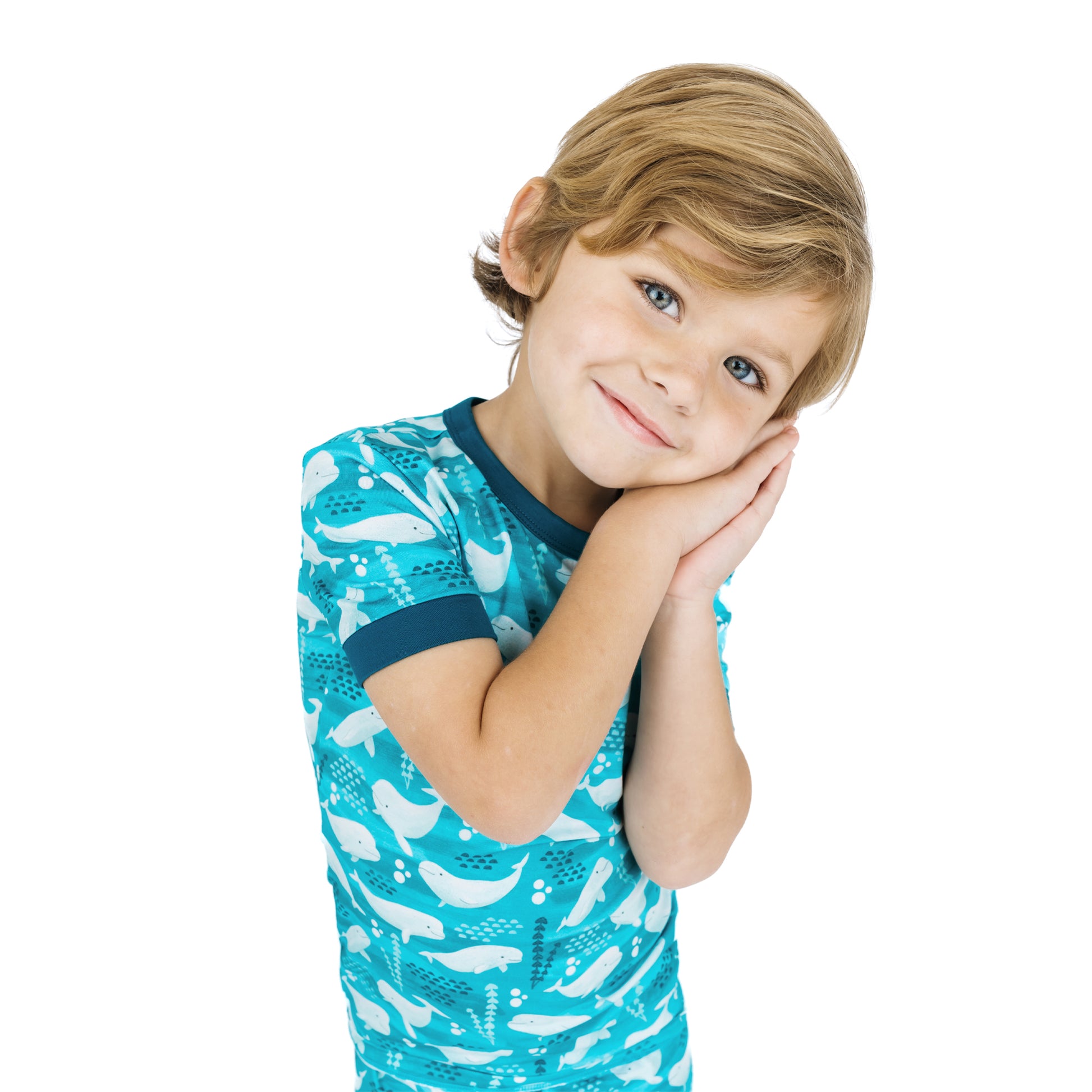 Child wearing a blue shirt with whale pattern on a white background