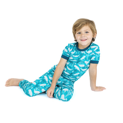 Child wearing a blue pajama set with white patterns on a white background