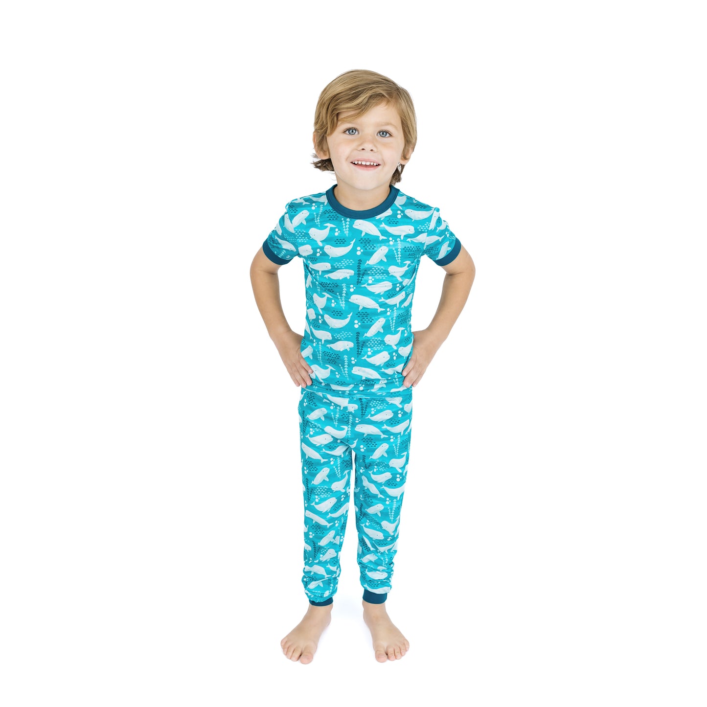 Child wearing a blue pajama set with whale pattern on a white background