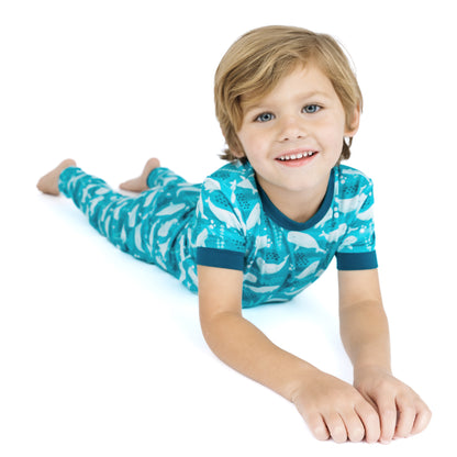 Child wearing a blue and white patterned pajama set on a white background
