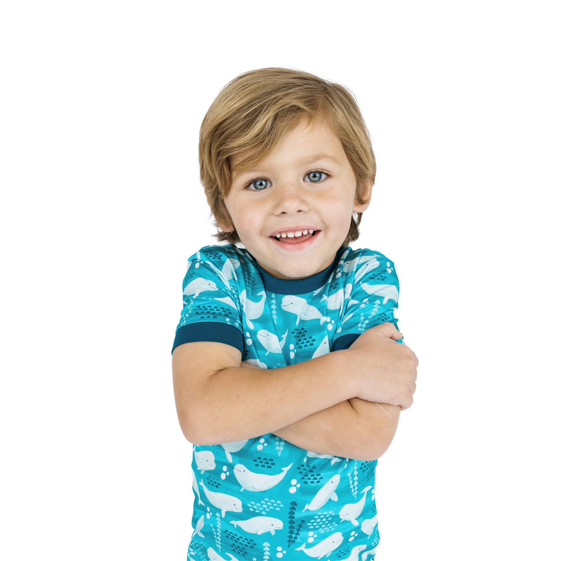 Child wearing a blue shirt with whale pattern on a white background