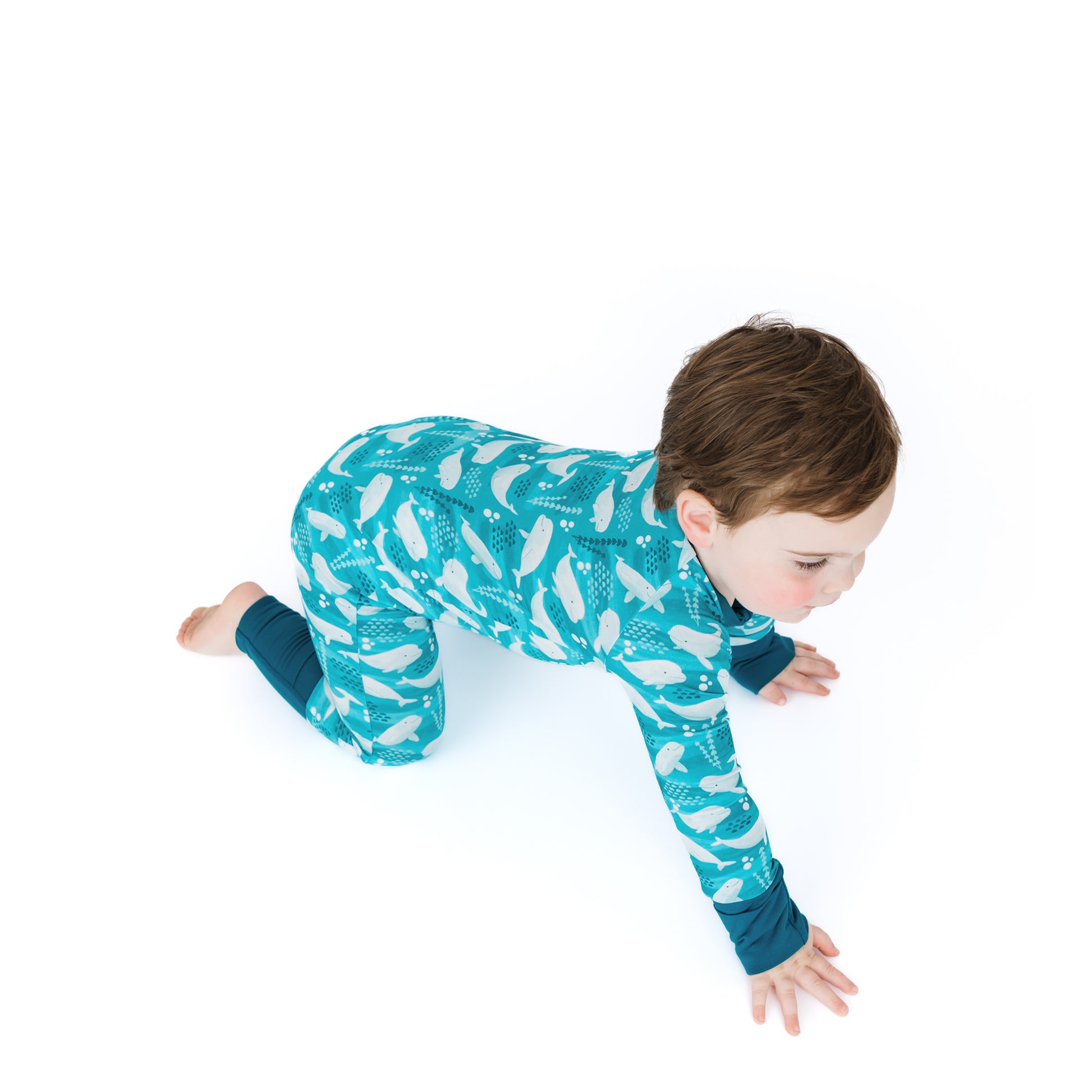 Child wearing a blue patterned onesie on a white background