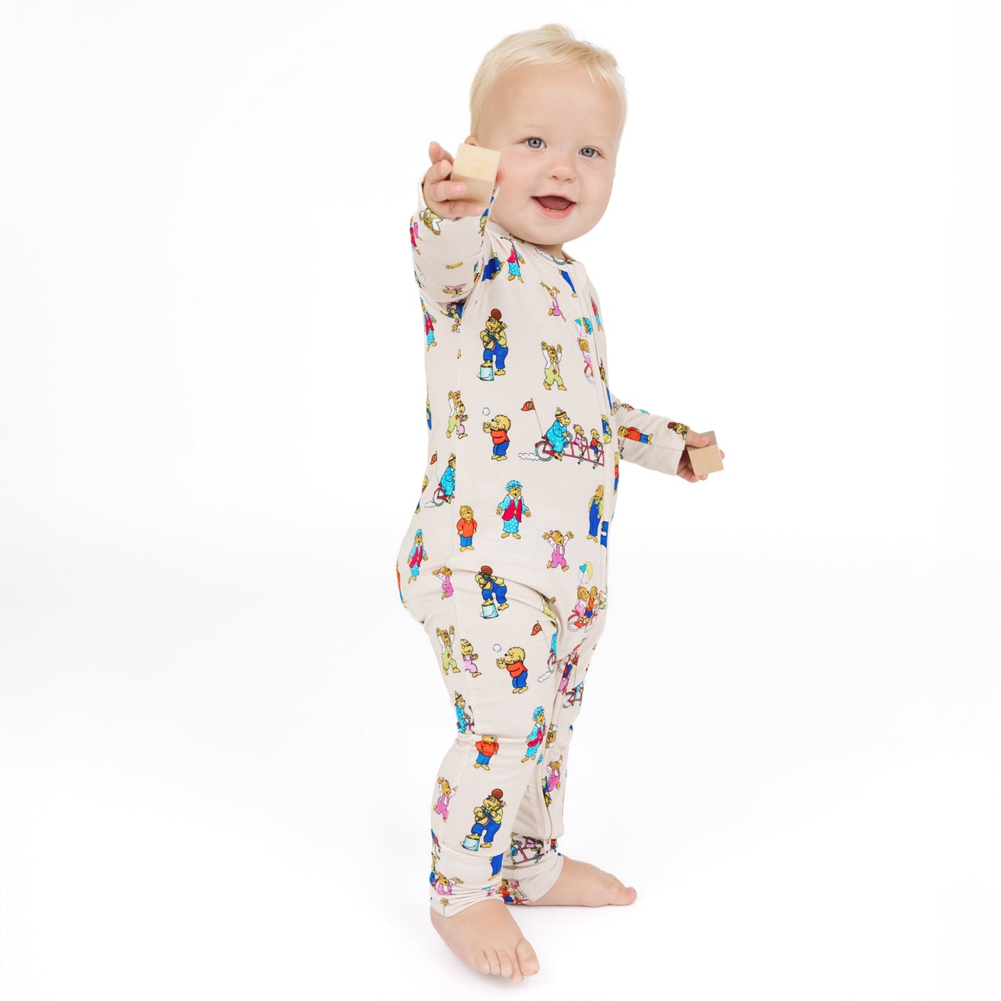 Baby wearing a colorful onesie with cartoon characters on a white background