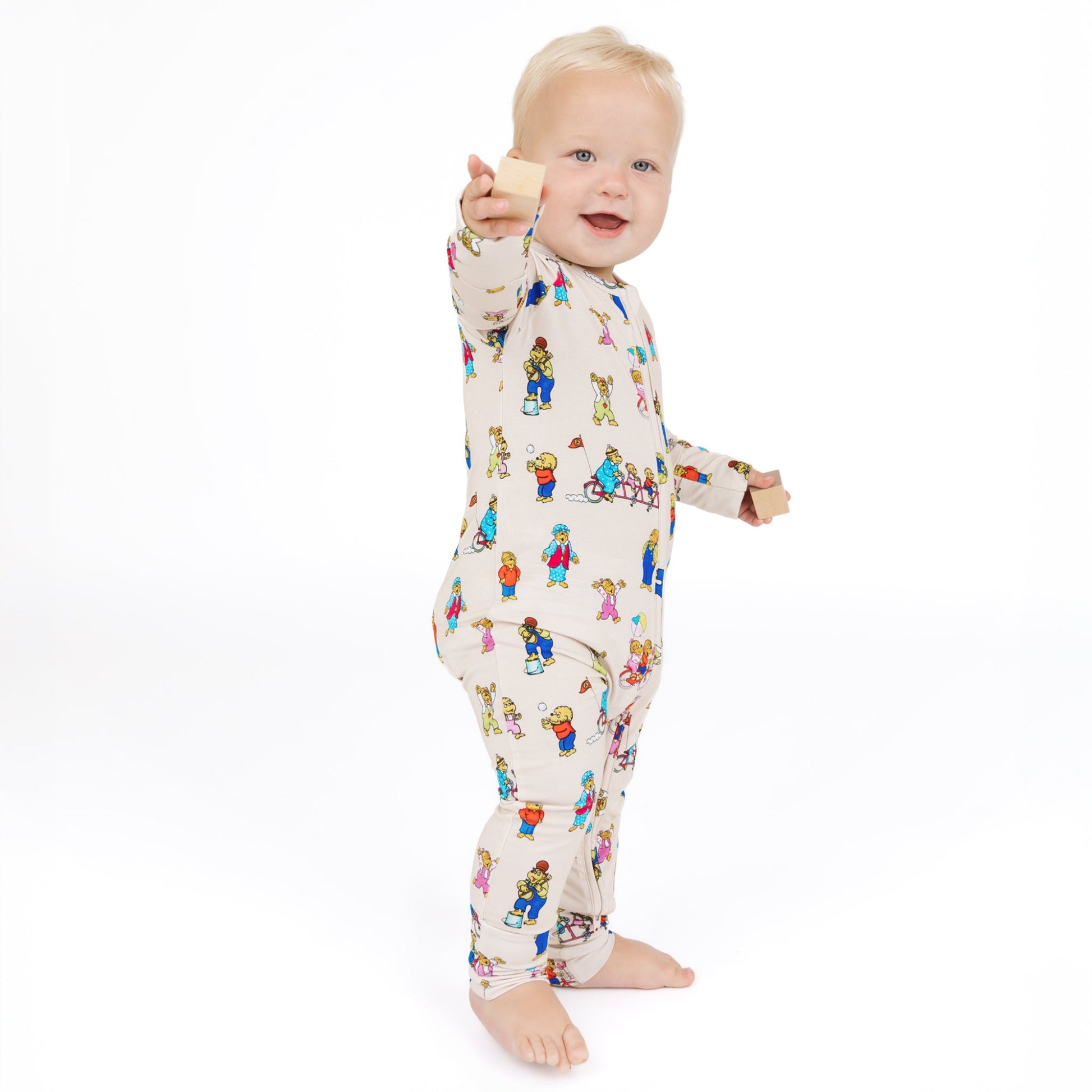 Baby wearing a colorful onesie with cartoon characters on a white background