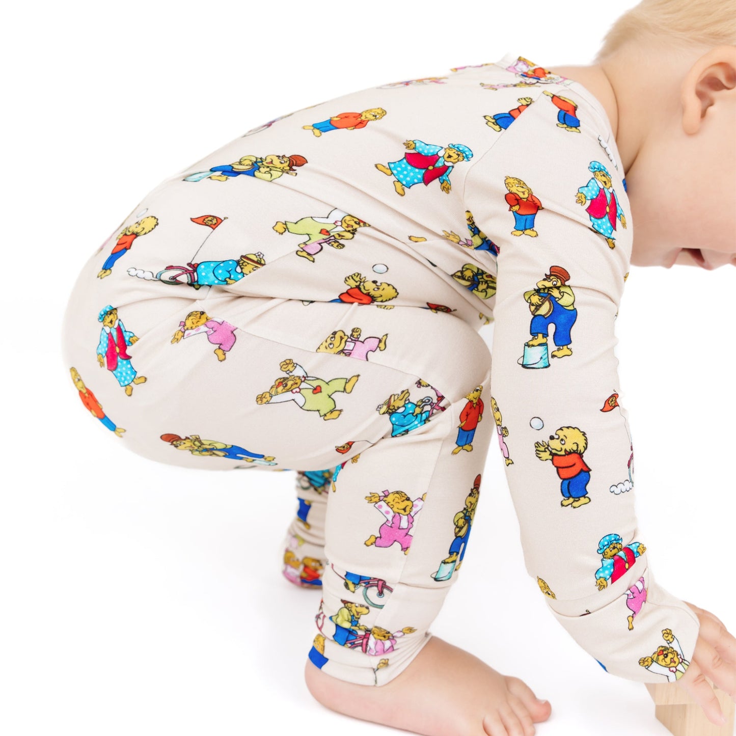 Baby wearing colorful patterned leggings on a white background