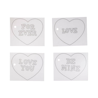 Four heart-shaped metal tags with engraved messages on a white background