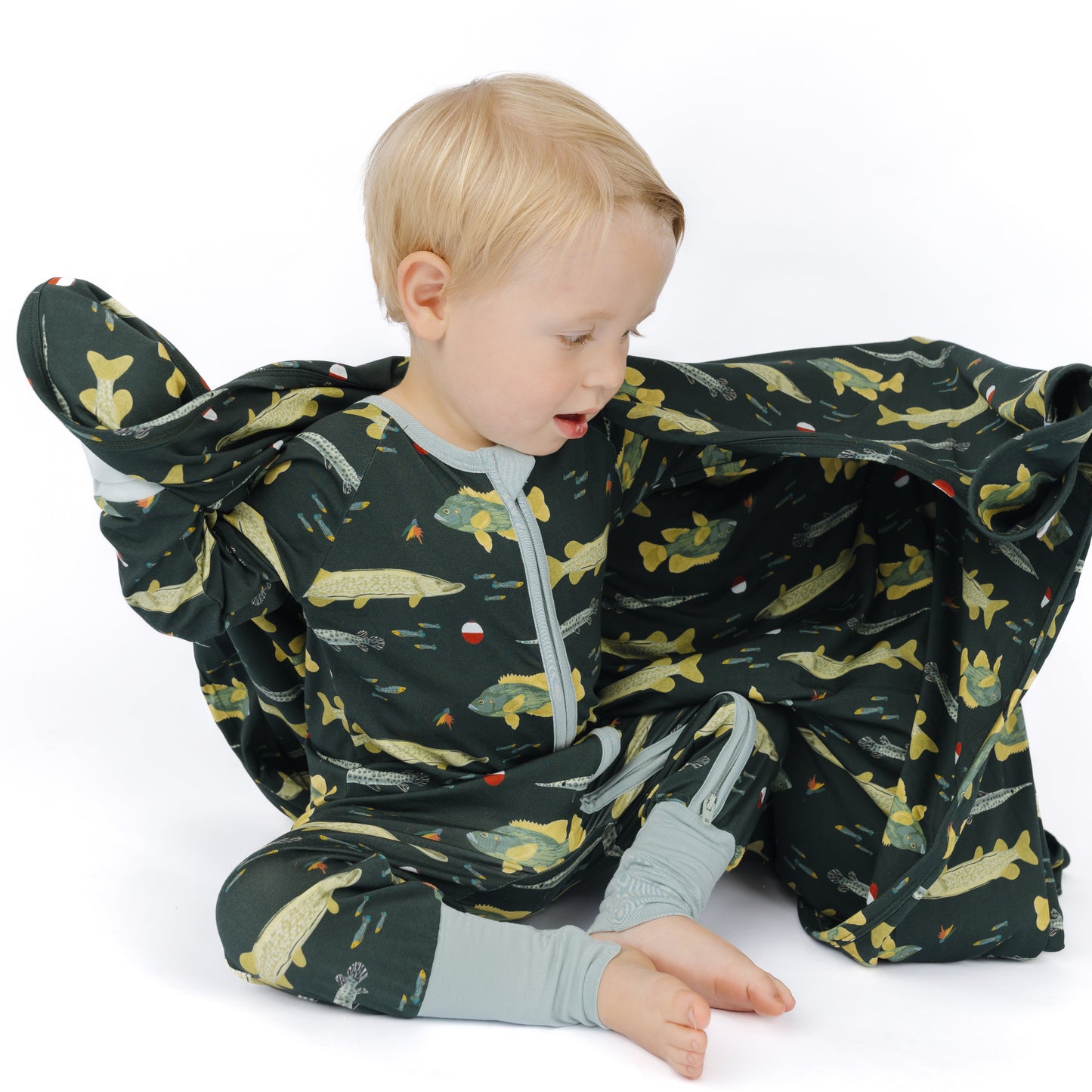 little boy in fish print pajamas and fish print blanket