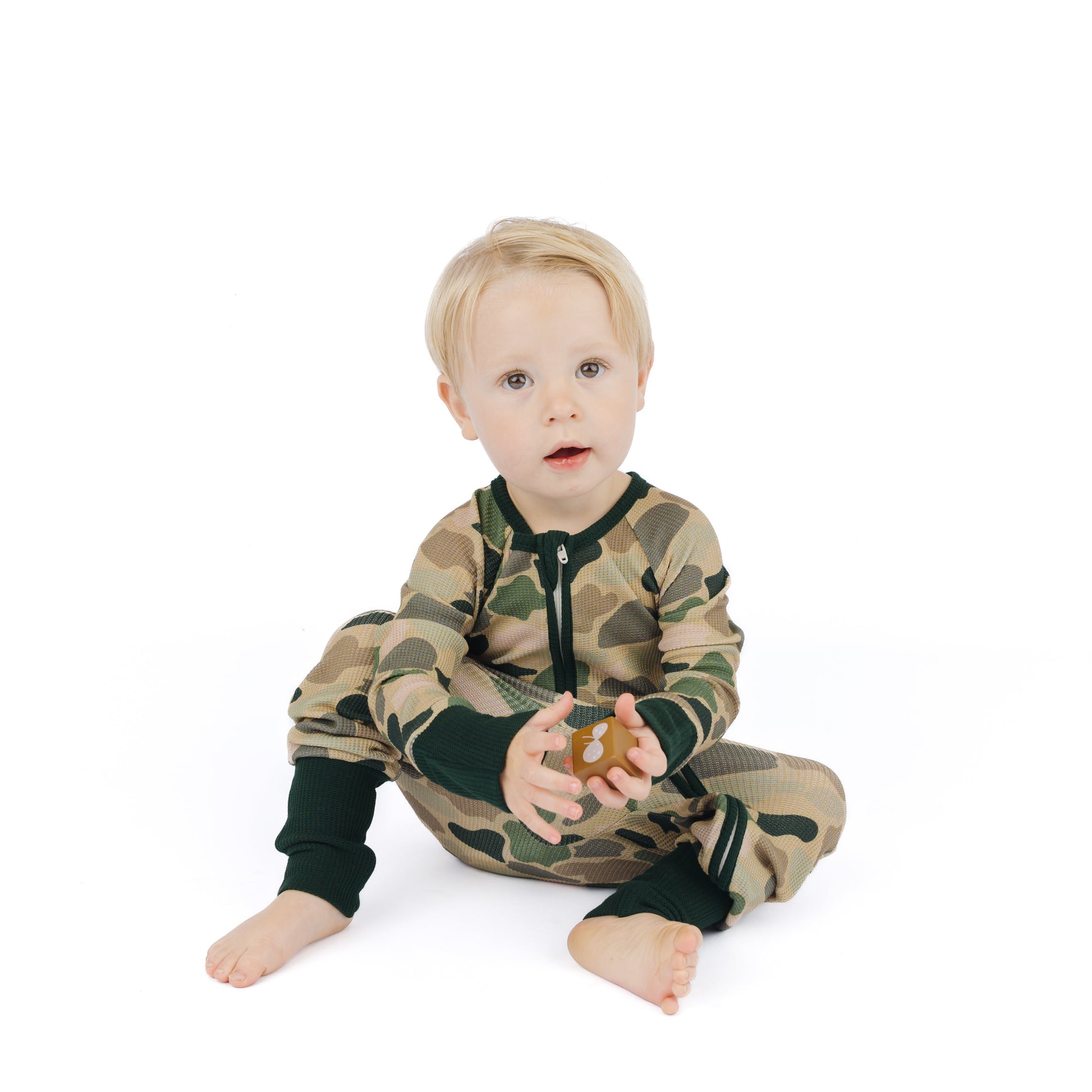 little boy wearing a camo print zipper convertible.