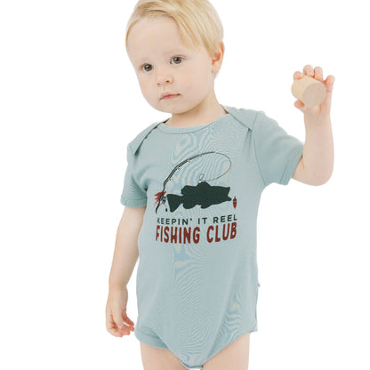 little boy in blue onesie with fish print
