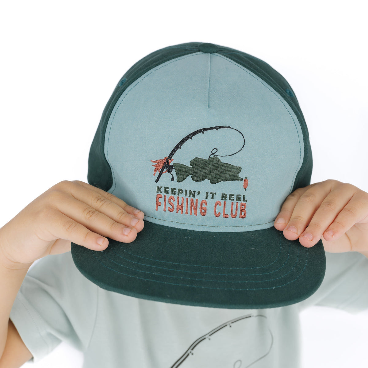 boy wearing blue hat with fish design on it