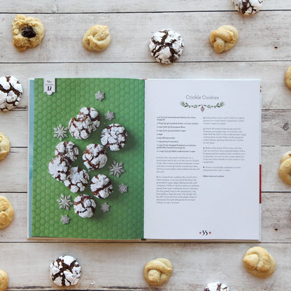 Open cookbook with crinkle cookies on a wooden surface