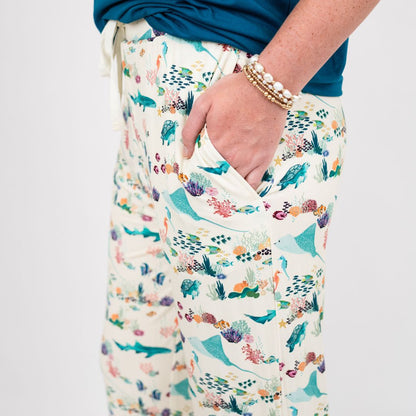 Woman wearing our Emerson and Friends Coral Reef Bamboo Relaxed Lounge Pajama Pants, featuring a serene ocean-inspired print with sea turtles, sharks, coral, and tropical fish on ultra-soft bamboo fabric perfect for all-day comfort and night.