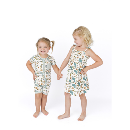 Two children wearing matching pajama sets with manatee prints on a white background
