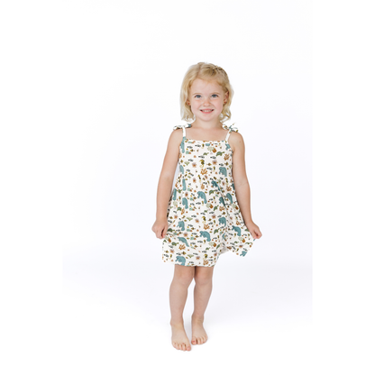 Young girl wearing a manatee patterned dress on a white background