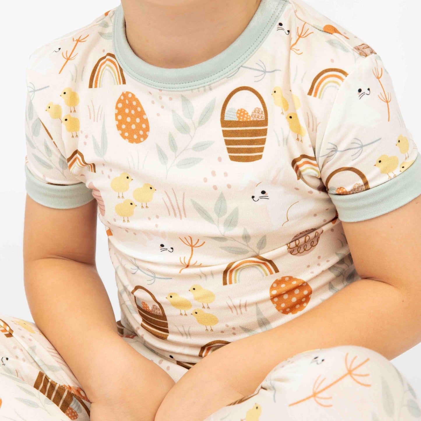 Close up of our two piece pajama featuring our hop to it print. The print features bunnies, chicks, easter eggs and more!
