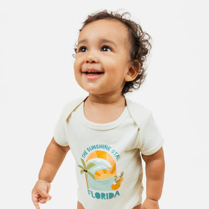 Florida Sunshine State baby onesie – soft & stretchy 100% cotton with unique vintage-inspired print, snap bottom, and fold-over shoulders for easy dressing.