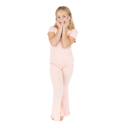 Young girl wearing pink pajamas with a white background