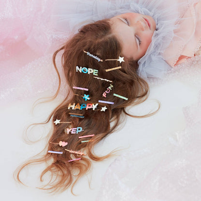 Child with colorful hair clips on a soft pink background