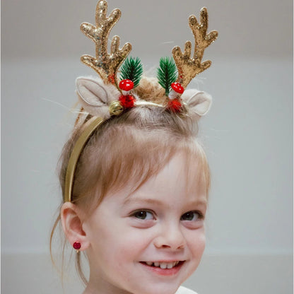 Little girl wearing the Rudolph antler headband featuring gold glittery antlers, jingle bells, fuzzy ears, and festive greenery from Great Pretenders