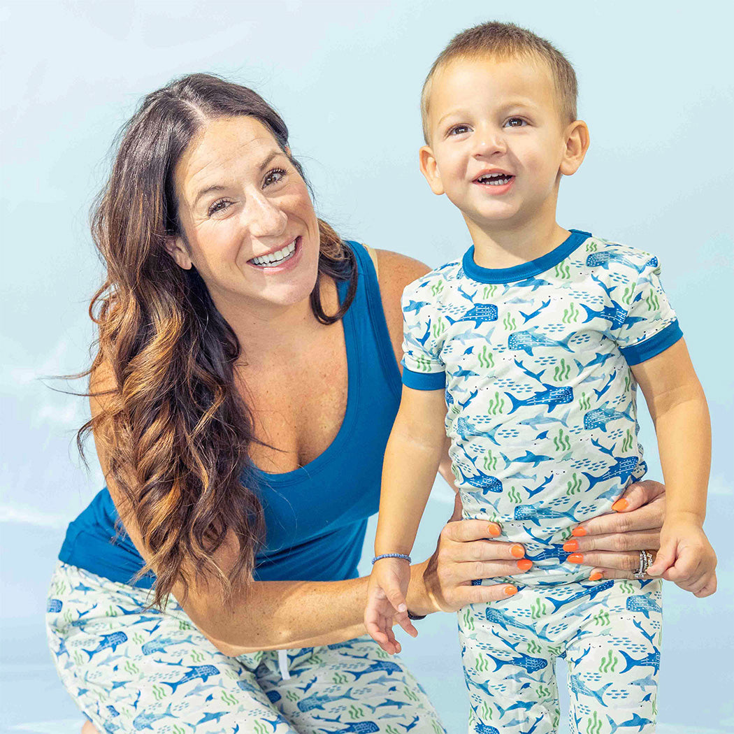 Mom and son smiling while matching in their Shark Friends bamboo pajamas.