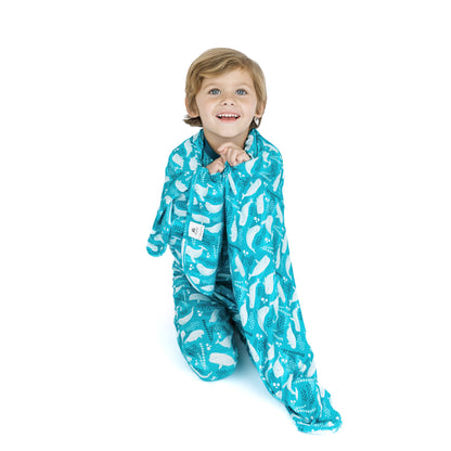 Child wearing a blue onesie with white patterns on a white background