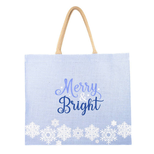 large tote bag thats light blue with white snowflakes along the bottom and it says Merry and Bright