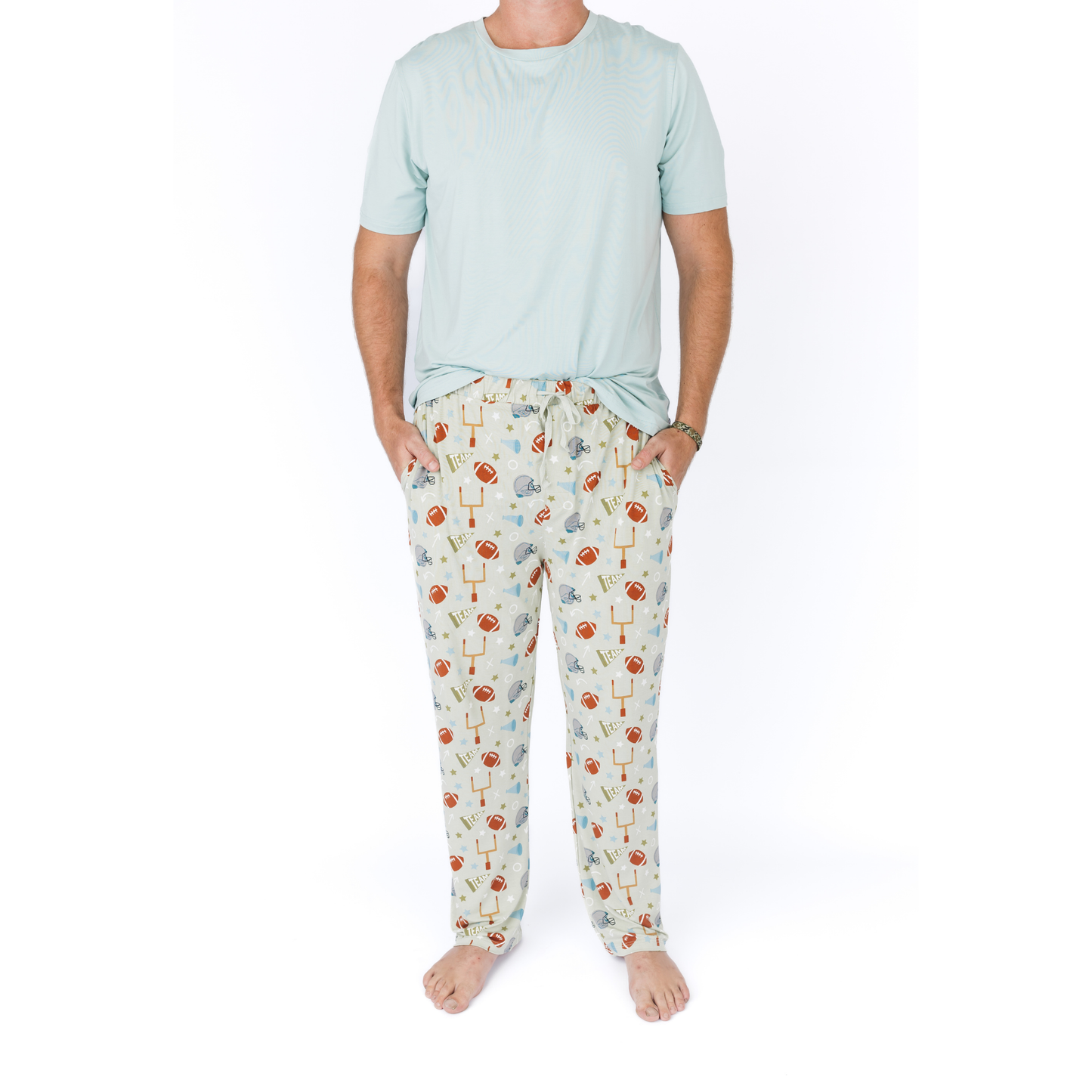 Person wearing a light blue t-shirt and patterned pajama pants on a white background