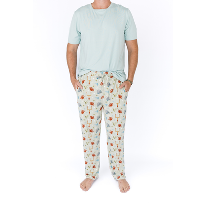 Person wearing a light blue t-shirt and patterned pajama pants on a white background