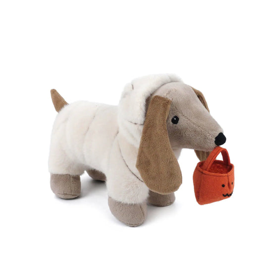 Stuffed animal puppy dressed as a Halloween mummy and holding a pumpkin candy bag