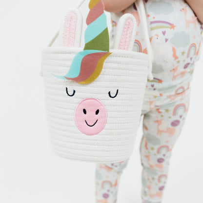 Little girl wearing our Magical Unicorn Bamboo Pajama set holding the Magical Unicorn Rope Basket. 