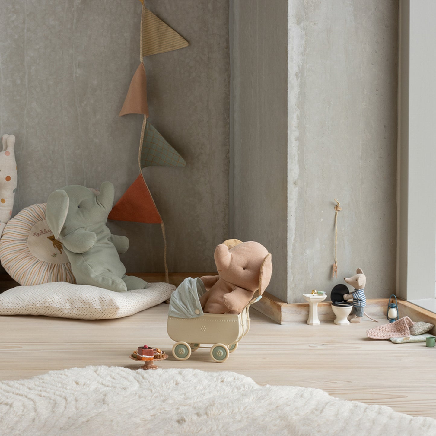 Children's room with plush toys and decorative elements on a wooden floor.