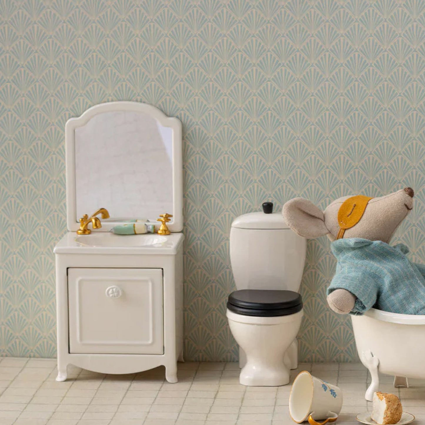 Children's bathroom set with sink, toilet, and bathtub featuring a teddy bear.