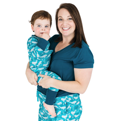 Woman and child wearing matching teal outfits with white patterns on a white background