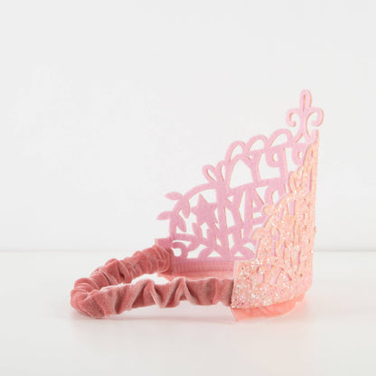 Pink headband with decorative lace design on a white background