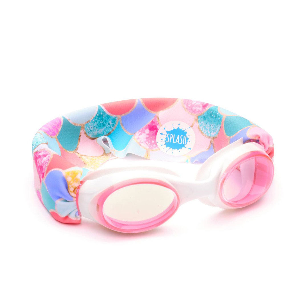 pink and white swim goggles with a thick fabric strap with mermaid print on the fabric