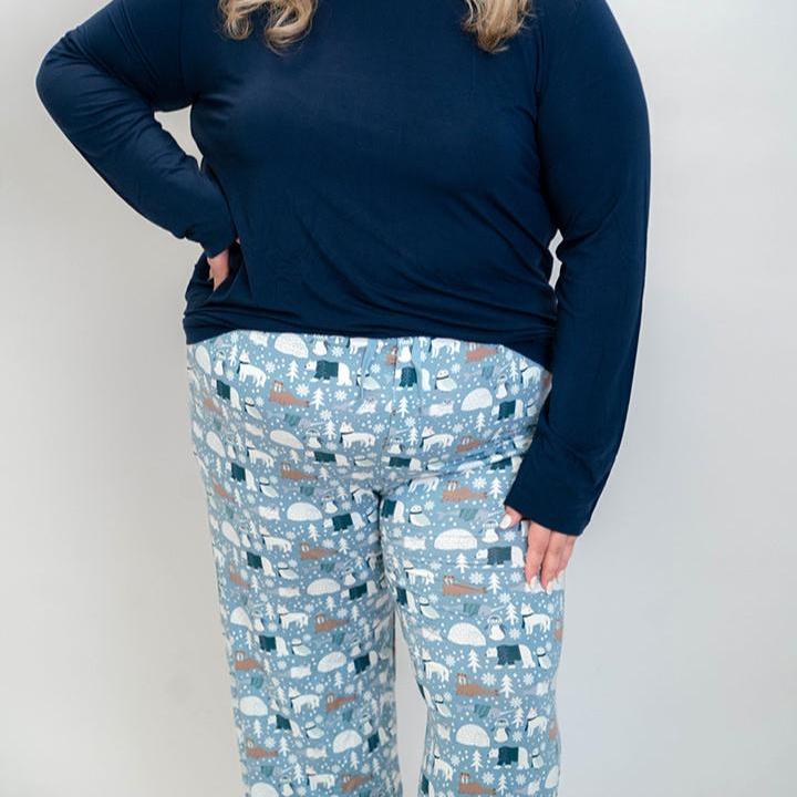 Model standing in white background with polar pals pajamas featuring polar bears ad navy top