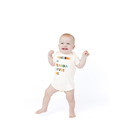 Baby wearing a onesie with text on a white background