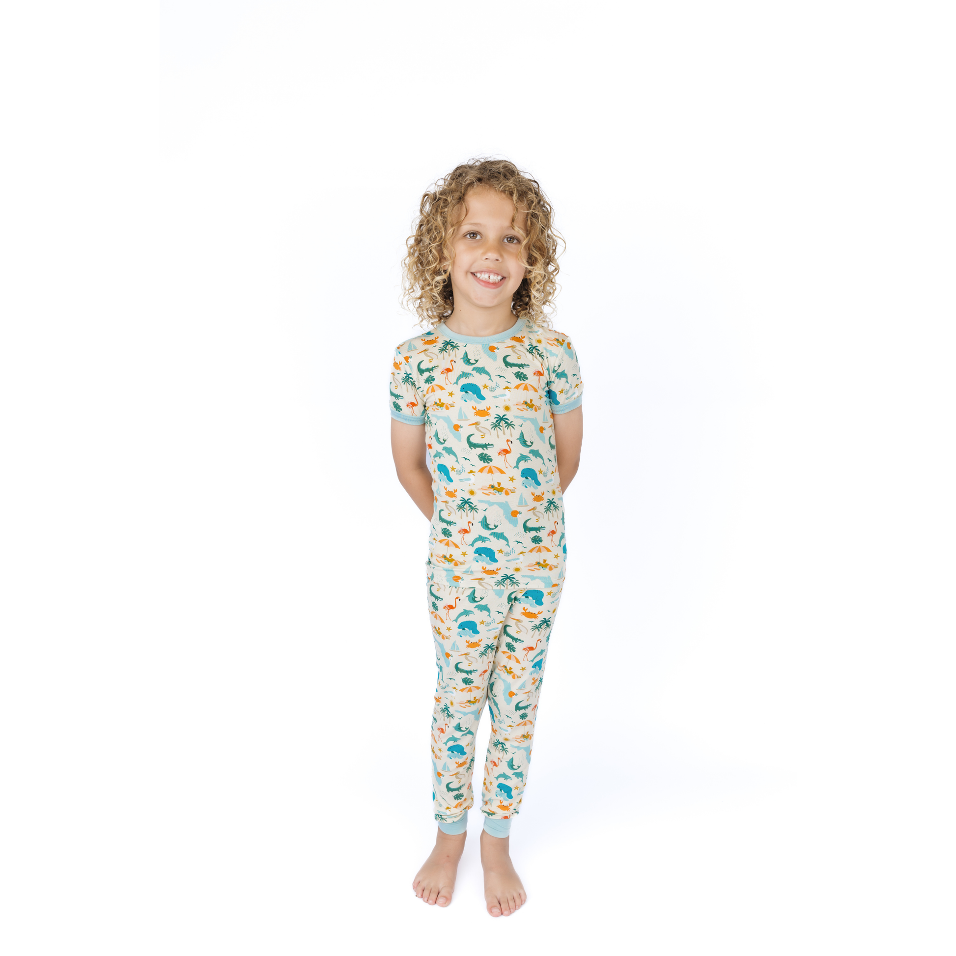 Child wearing a florida theme patterned pajama set on a white background