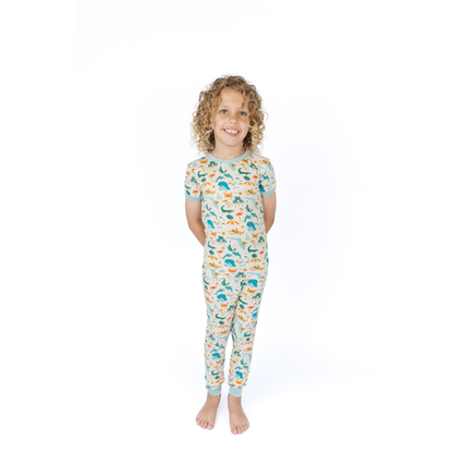 Child wearing a florida theme patterned pajama set on a white background