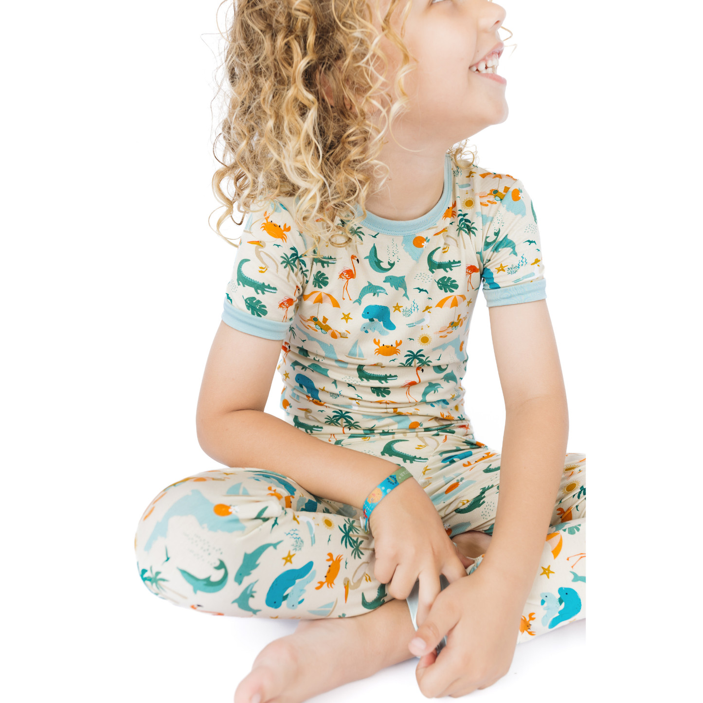 Child wearing a florida theme patterned outfit on a white background