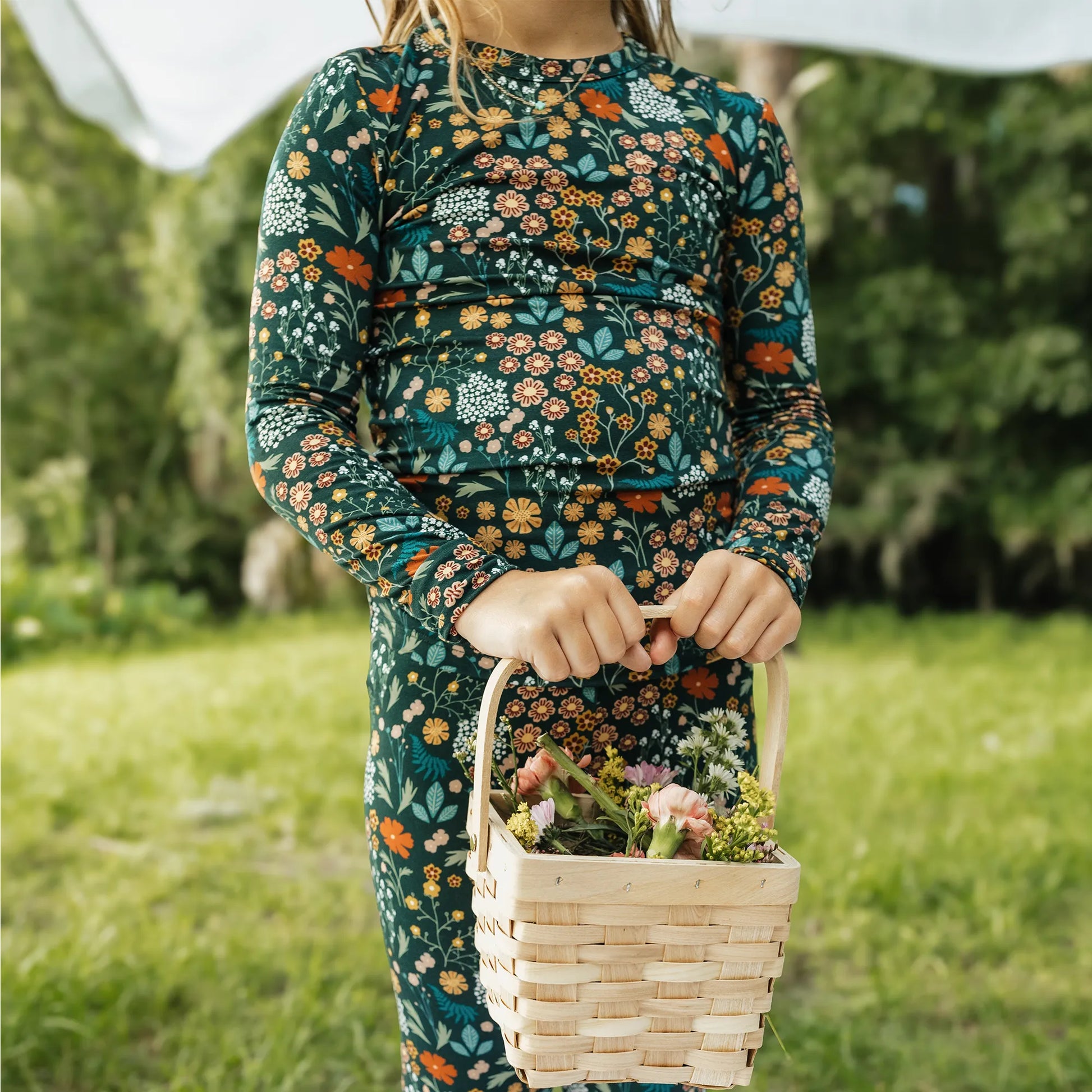 girl wearing dark green floral print pajama set