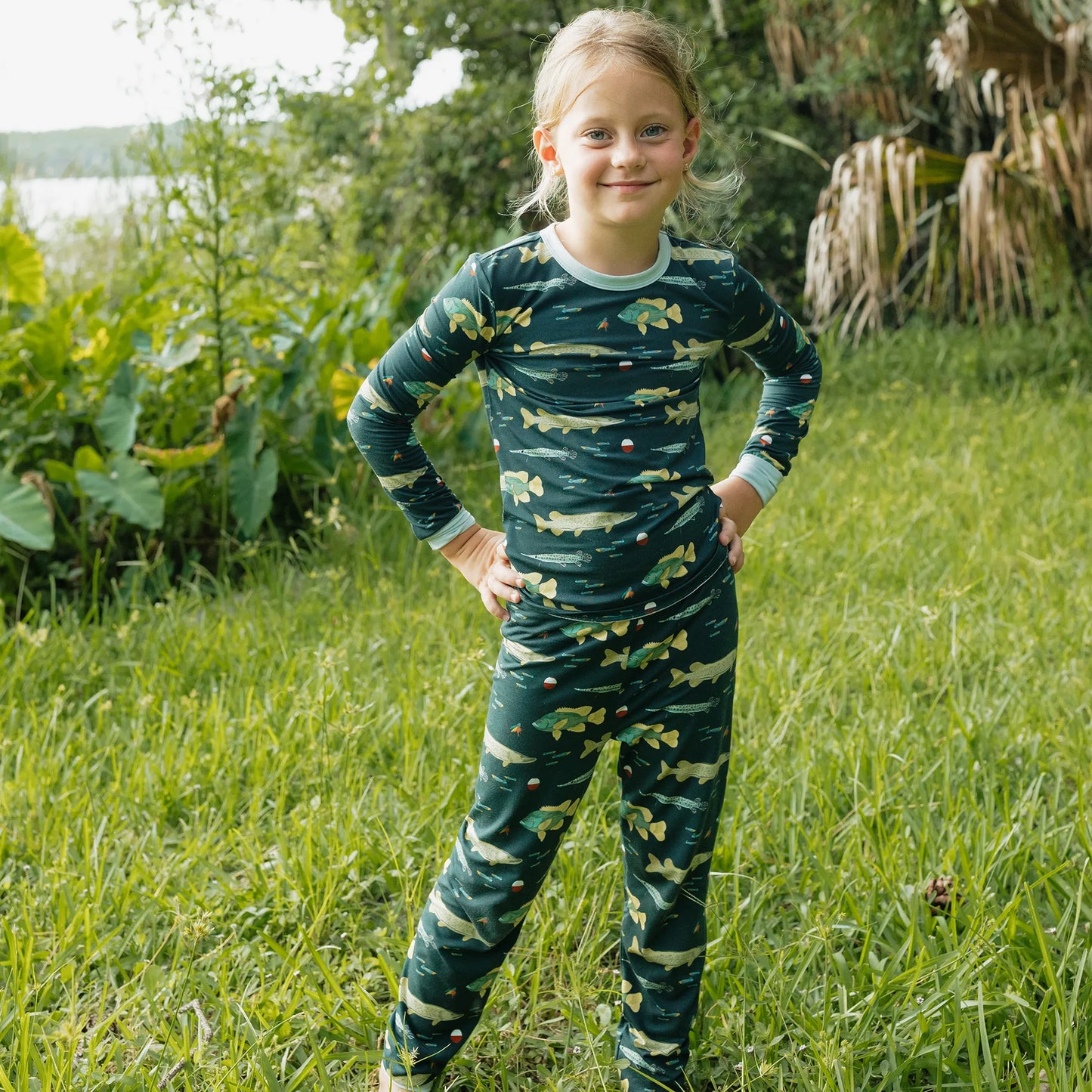 girl wearing fish print pajama set on a greenery background. 